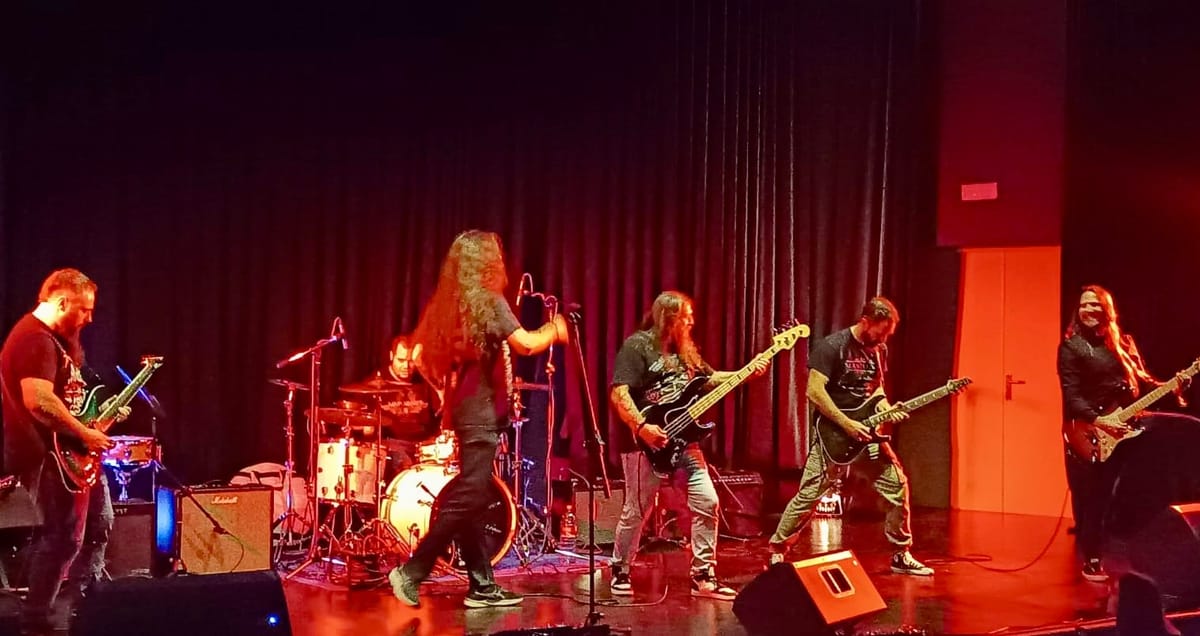 Banda tocando en directo bajo luces rojas de escenario
